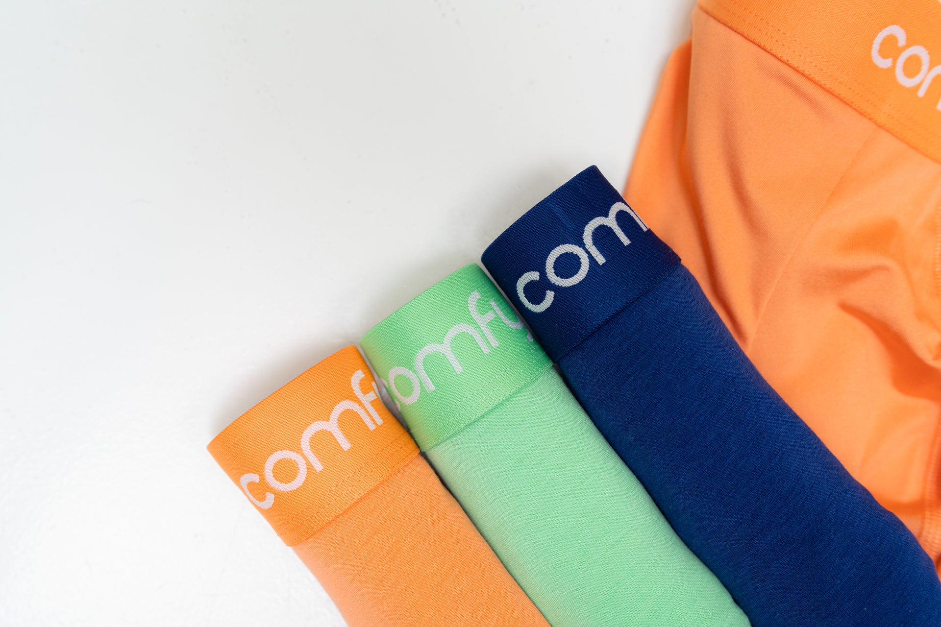 3 folded Comfyballs boxers in the colours Melon, Summer Green and Blue.