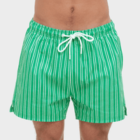 Green and white striped swim shorts on a plain background