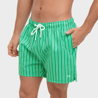 Green and white striped swim shorts on a plain background