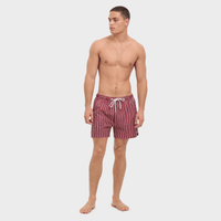 Man wearing red and white striped swim shorts on a light gray background