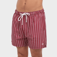 Red and white striped swim shorts on a plain background