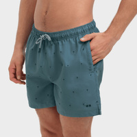 Teal swim shorts with small patterns on a white background