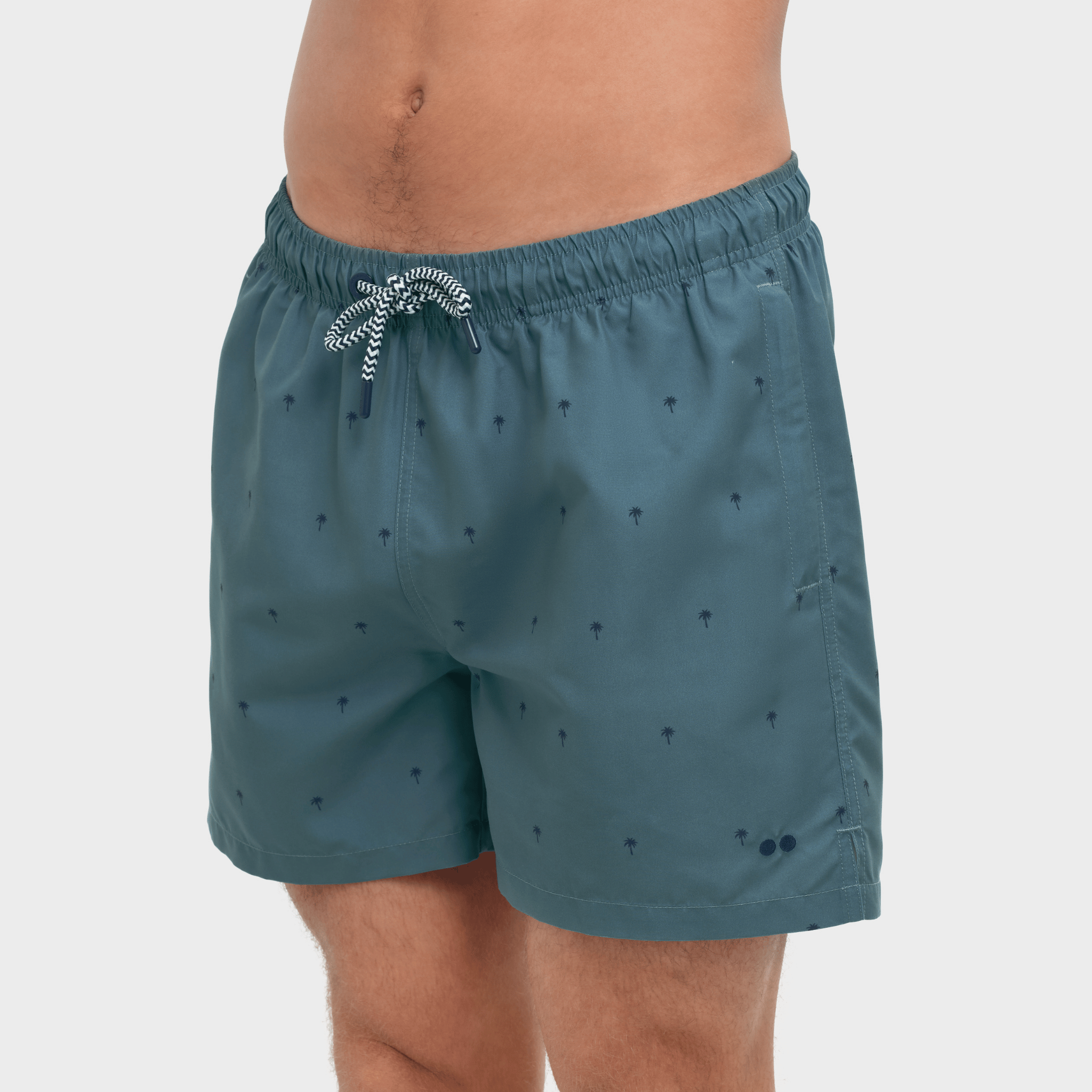 Teal swim shorts with a subtle pattern on a white background