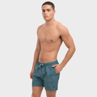 Man wearing teal swim shorts on a white background