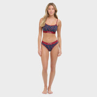 Woman wearing a navy and red bikini with floral pattern on a white background