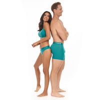 Man and woman wearing matching teal underwear on a white background